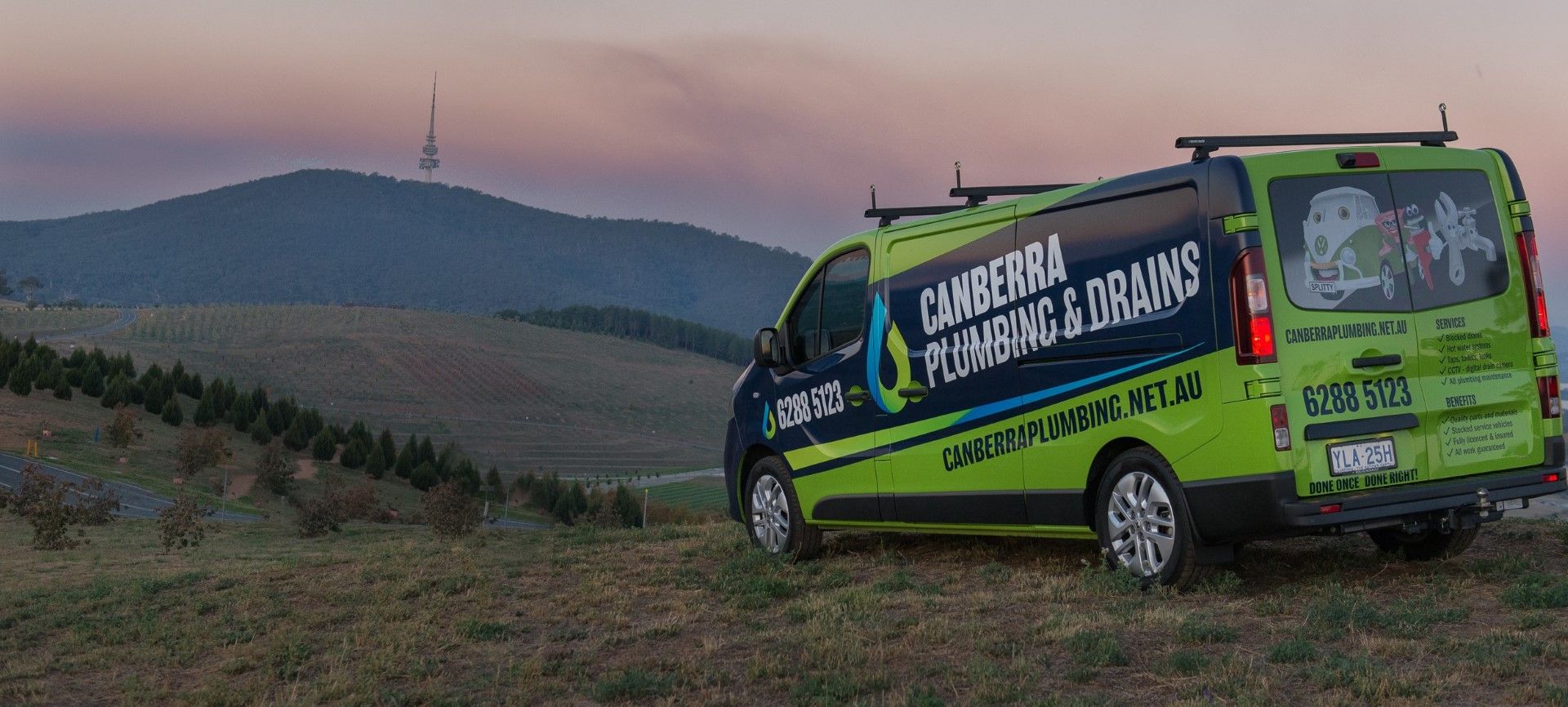 Plumber's van parked in Canberra with mountains in background.